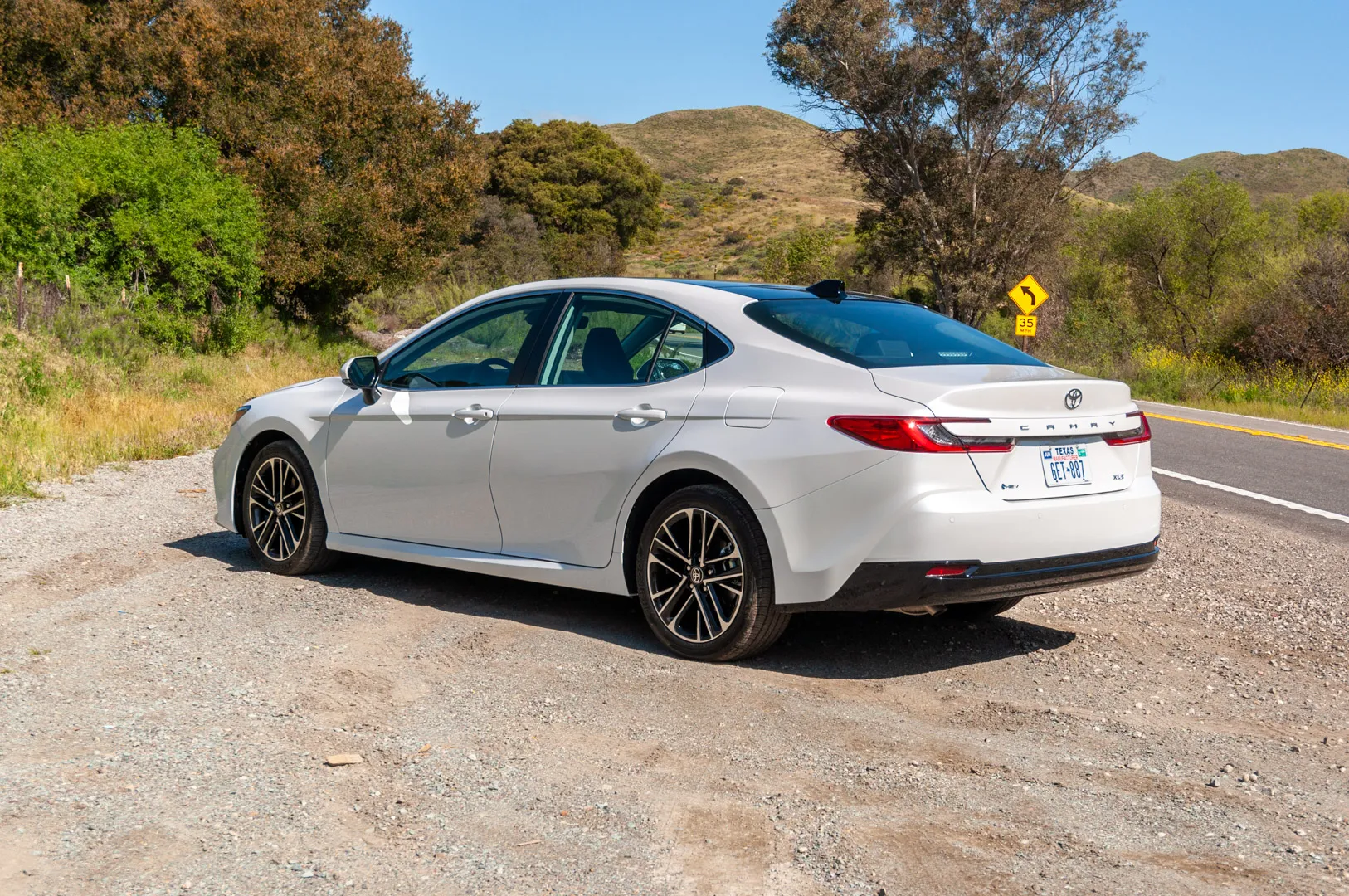 2025 Toyota Camry rear three-quarter view with full-width LED tail lamps