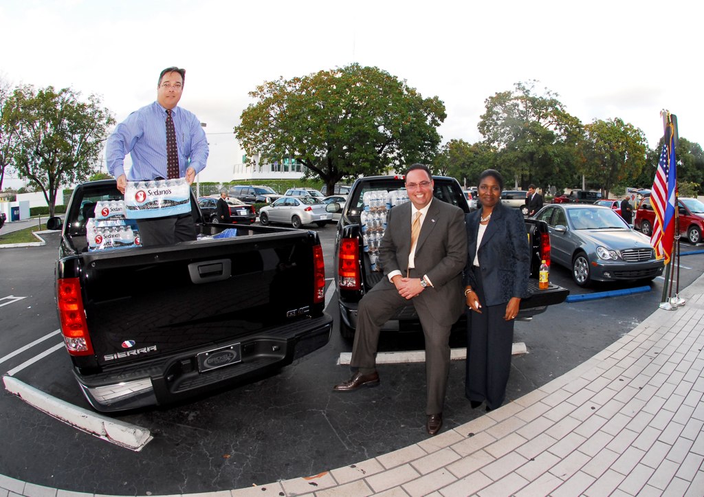 GM representatives with GMC Sierras and supplies bound for Haiti