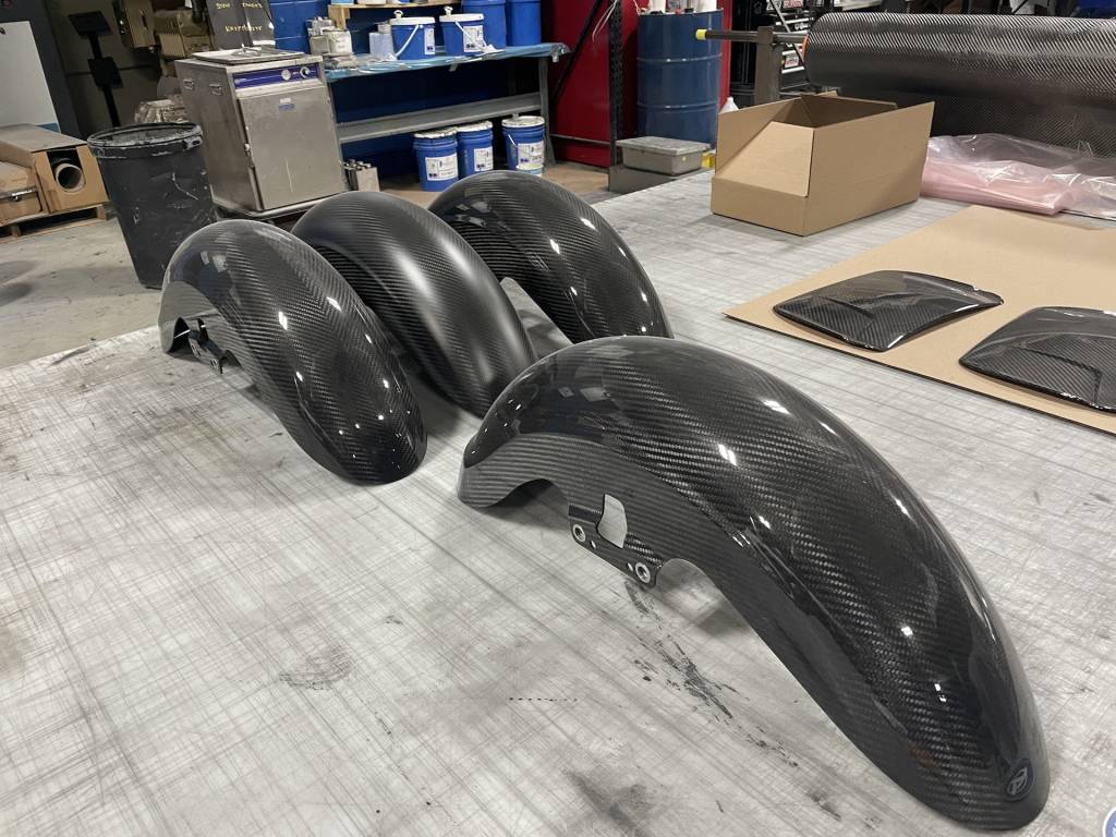 Carbon-fiber parts are created by first creating a master or plug (top), then making a mold off of it (bottom left), laying in the carbon fiber, then trimming it. These fenders (bottom right) are for a Harley-Davidson motorcycle.