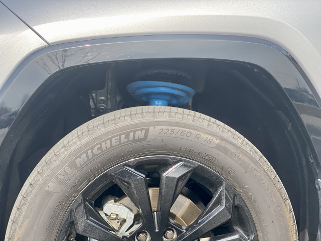 The 2023 Toyota RAV4 Hybrid XSE AWD sports SUV add-ons such as mud guards, running boards, a roof rack, and even blue coil springs poking through chunky wheel arches. 