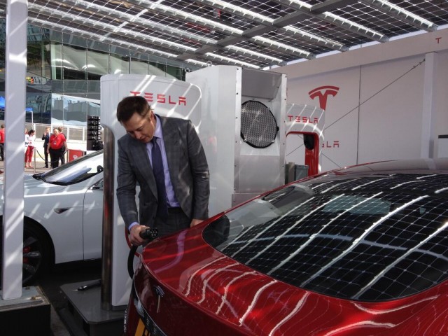 Elon Musk plugs a Tesla Model S into a Supercharger (Image: deanslavnich on Twitter)