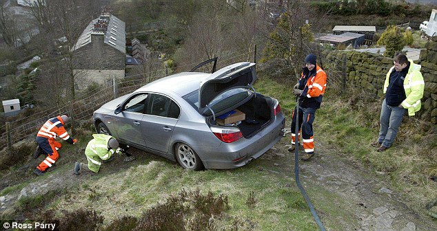 Emergency workers in Tormoden, West Yorkshire, rescue a BMW 5-Series. Photo: Ross Parry / Daily Mail